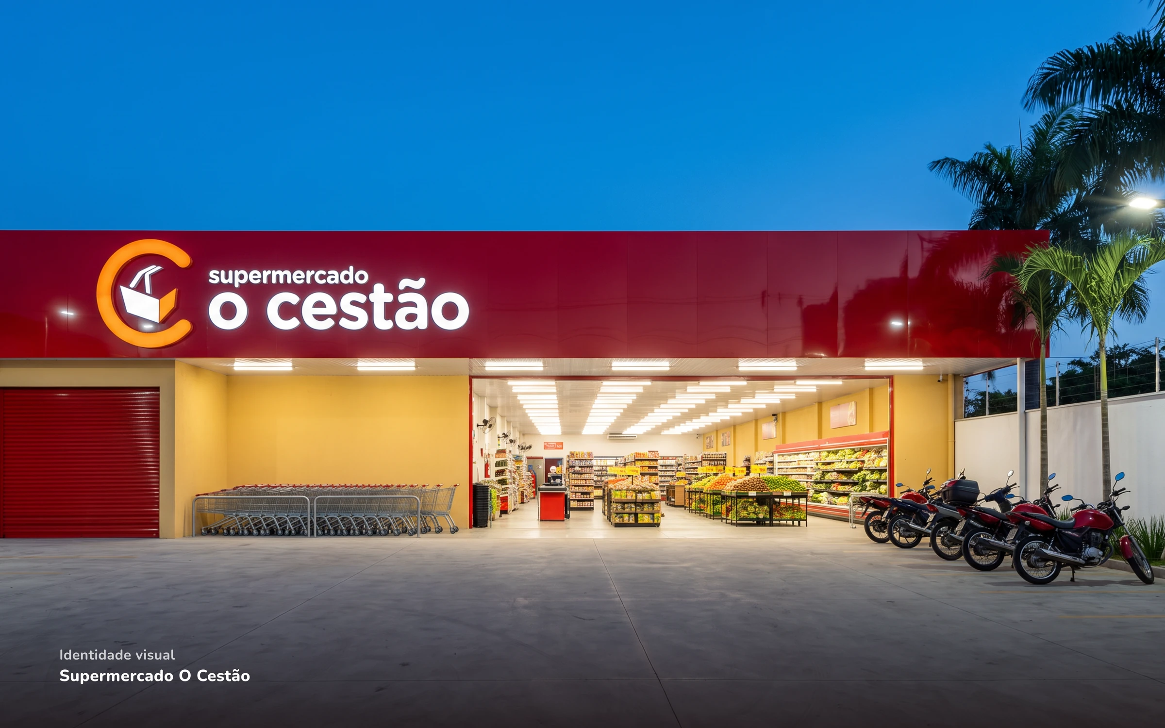 Fachada do Supermercado O Cestão ao anoitecer, com o letreiro vermelho iluminado