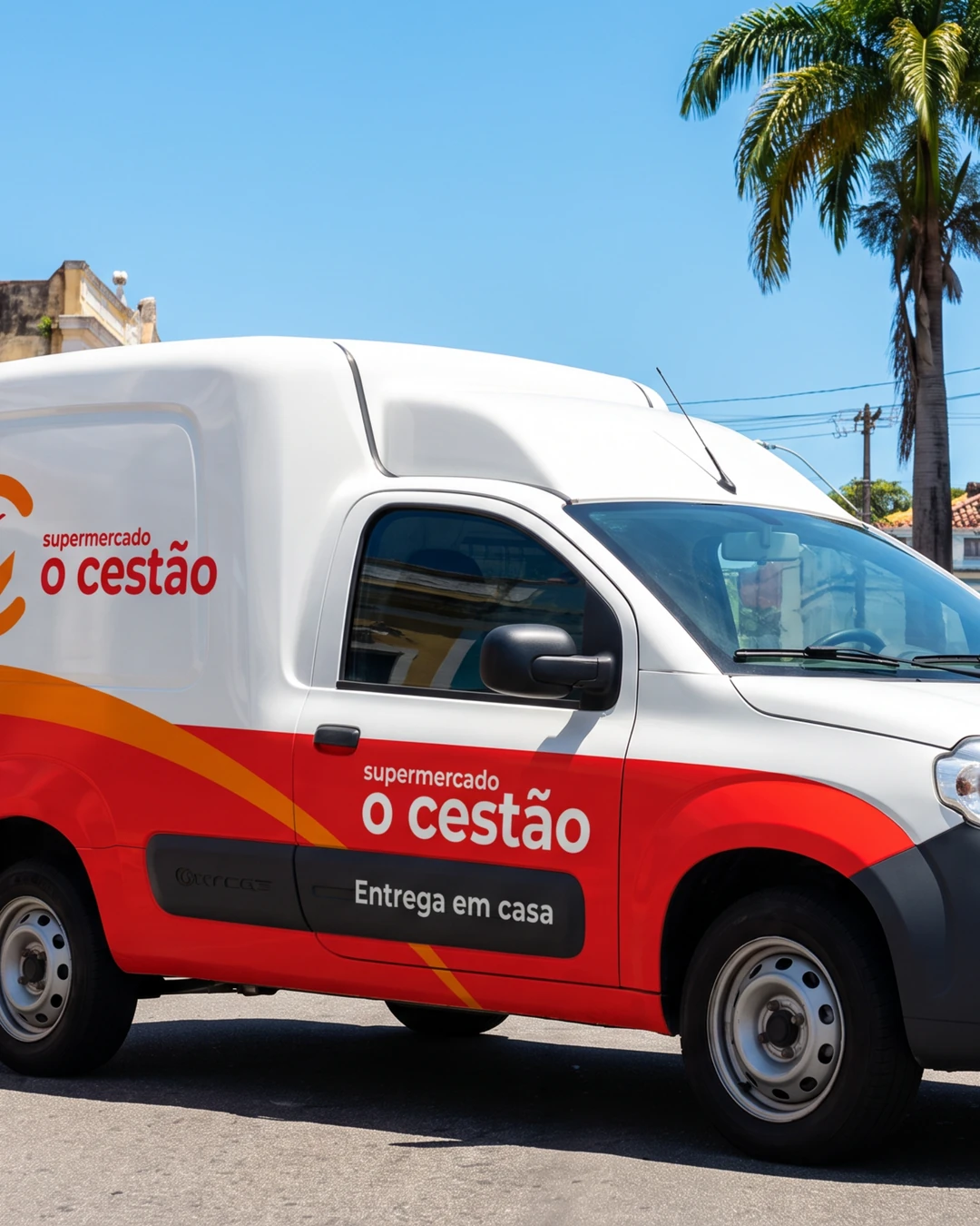 Van de entregas branca e vermelha do Cestão em uma rua com casarios coloridos