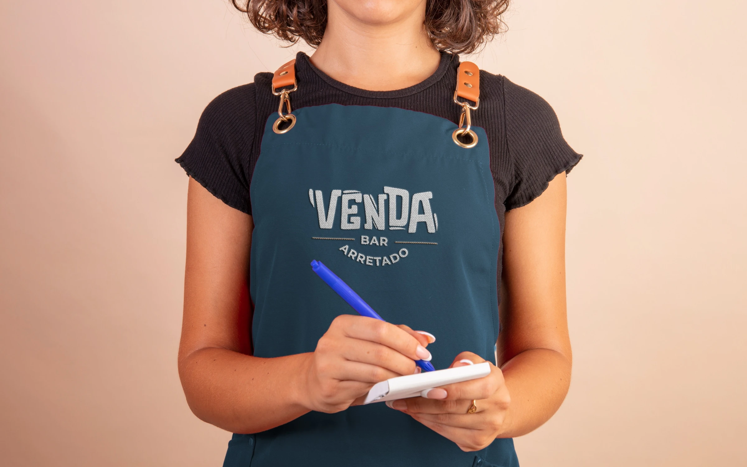 Atendente com avental azul do Venda anotando um pedido